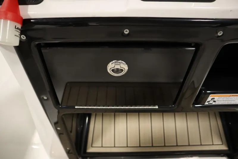 Slide: The Image of 2024 Yamaha Boats 222 FSH Sport storage compartment with sleek black finish and secure latch. - 41