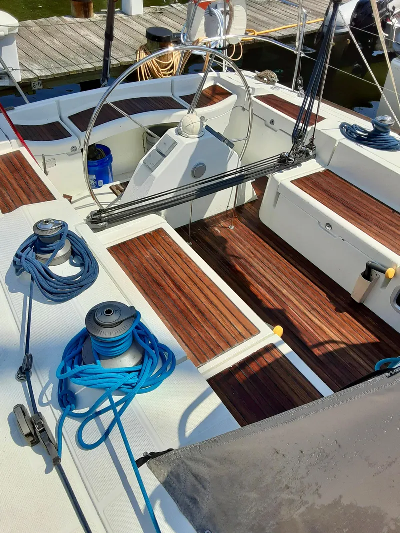 Slide: The Image of Cockpit of 2005 Beneteau First 44.7 sailboat with wooden seating and blue ropes. - 7