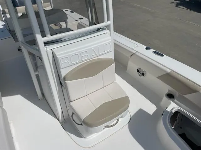 Slide: The Image of 2016 Robalo 246 Cayman boat interior with cushioned seating and storage. - 14