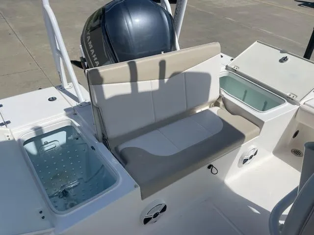 Slide: The Image of 2016 Robalo 246 Cayman boat seating area with storage compartments and Yamaha engine. - 7