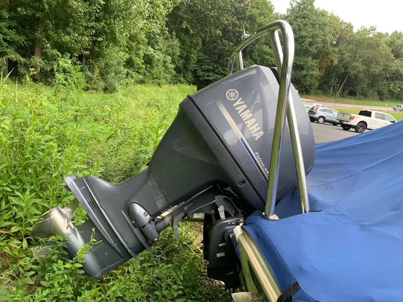 Slide: The Image of 2013 NauticStar 210 Coastal boat with Yamaha outboard motor in a parking lot. - 2