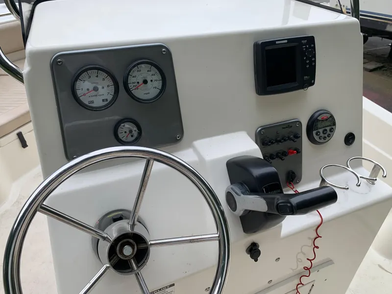 Slide: The Image of 2013 NauticStar 210 Coastal boat dashboard with steering wheel, gauges, and controls. - 5