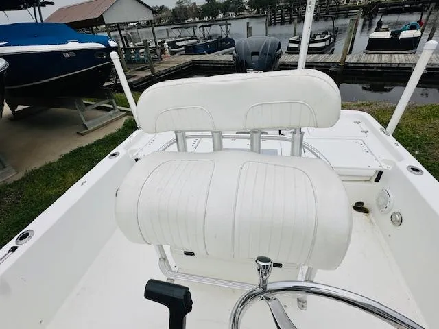 Slide: The Image of 2012 Sea Fox 22 XT boat interior with white seating, docked near a marina. - 8