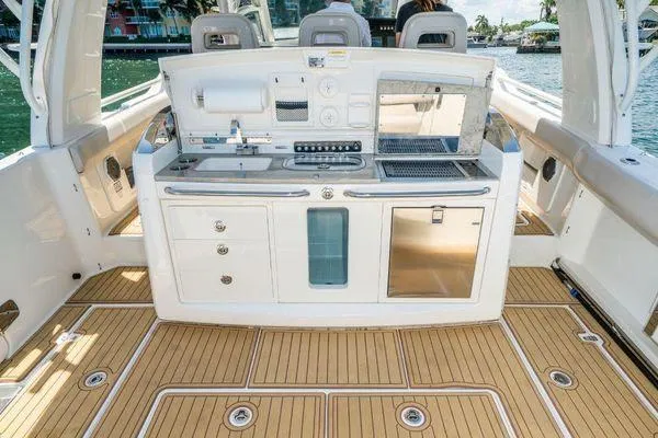 Slide: The Image of Boston Whaler 42 OUTRAGE 2017 boat deck with kitchen amenities and teak flooring. - 24