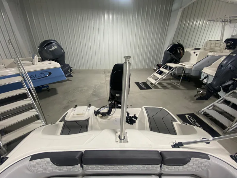 Slide: The Image of 2024 Bayliner Element M15 boat interior in showroom with other boats. - 7