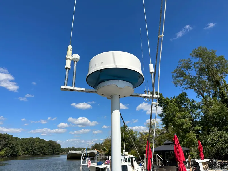 Slide: The Image of 1983 Brewer 42 Center Cockpit sailboat with radar equipment on a sunny day by a river. - 12