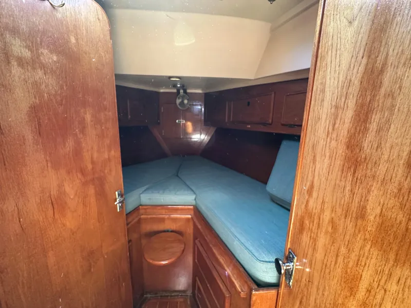 Slide: The Image of 1983 Brewer 42 Center Cockpit cabin interior with wooden finish and blue cushions. - 22
