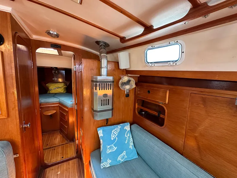 Slide: The Image of 1983 Brewer 42 Center Cockpit interior with wood paneling, seating, and cozy cabin space. - 23