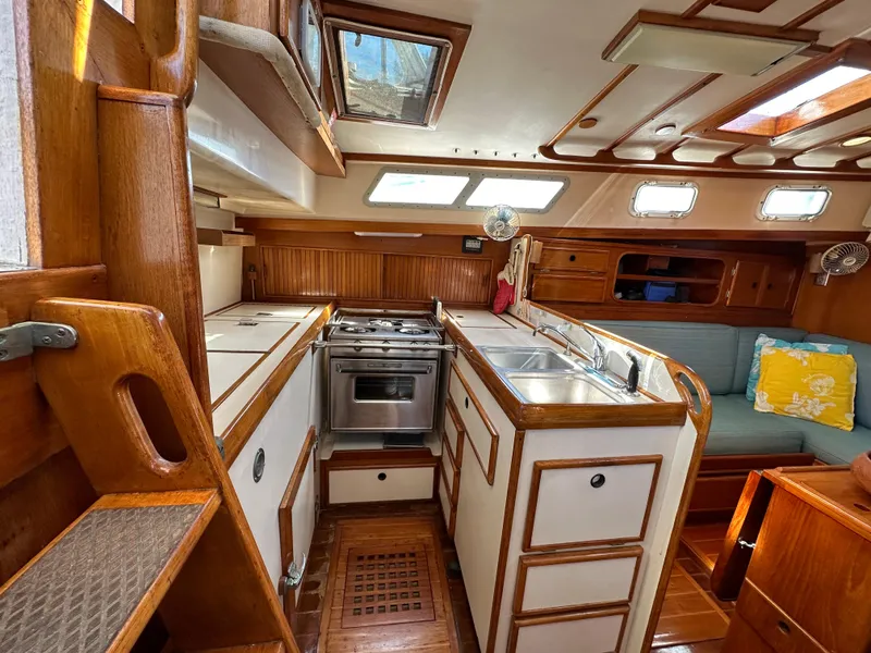 Slide: The Image of Interior of 1983 Brewer 42 Center Cockpit sailboat with wood cabinetry and kitchen amenities. - 24
