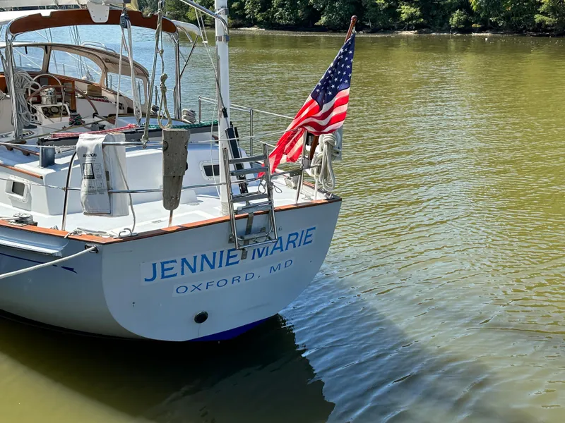 Slide: The Image of Sailboat "Jennie Marie" docked, displaying American flag, Brewer 42 Center Cockpit, 1983 model. - 32