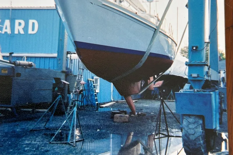 Slide: The Image of 1983 Brewer 42 Center Cockpit sailboat in a shipyard, supported by stands. - 34