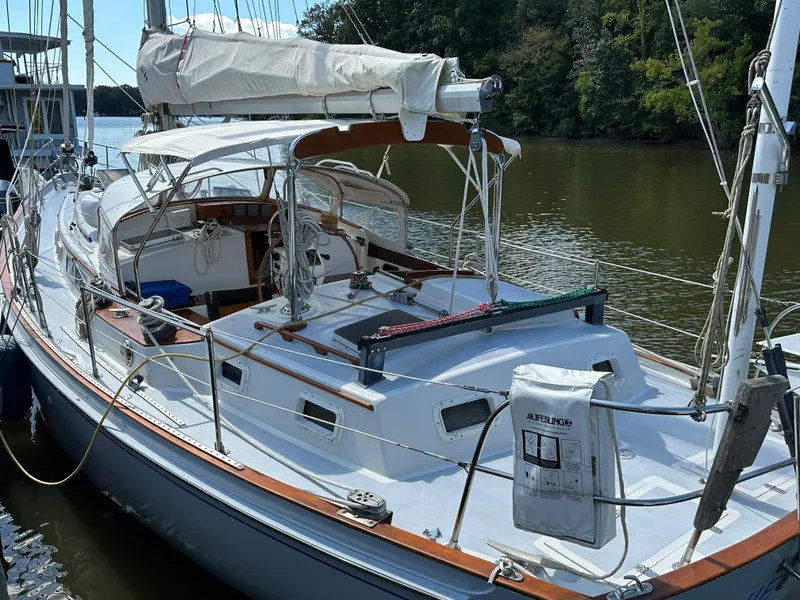 Slide: The Image of 1983 Brewer 42 Center Cockpit sailboat docked on a calm river. - 6