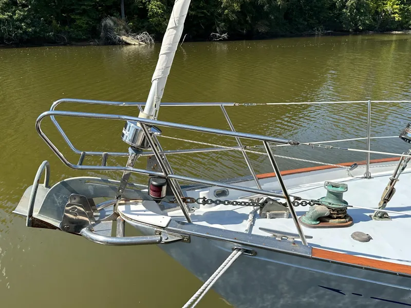 Slide: The Image of 1983 Brewer 42 Center Cockpit sailboat bow with anchor and railing on calm water. - 8