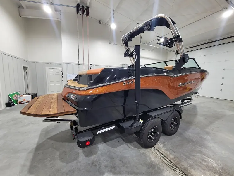Slide: The Image of 2024 MasterCraft NXT22 boat in a garage, rear view. - 10