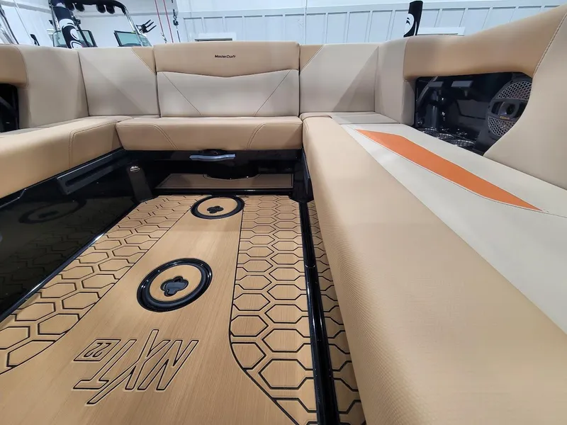 Slide: The Image of 2024 MasterCraft NXT22 boat interior with beige and orange seating. - 12
