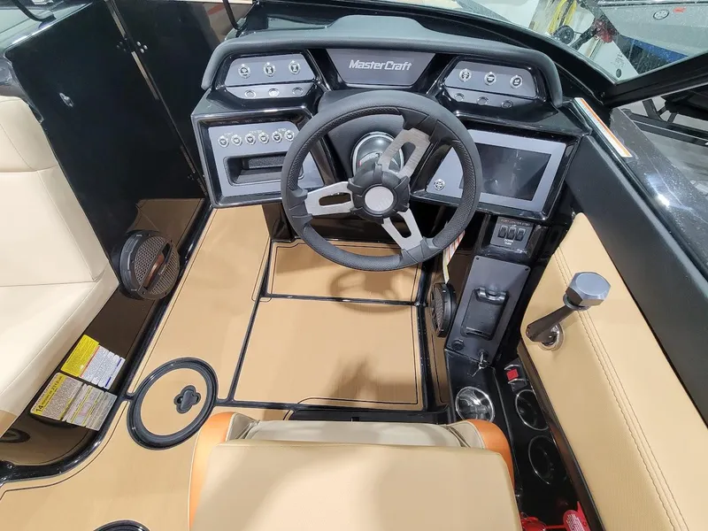 Slide: The Image of 2024 MasterCraft NXT22 boat interior, featuring a modern dashboard and steering wheel. - 13