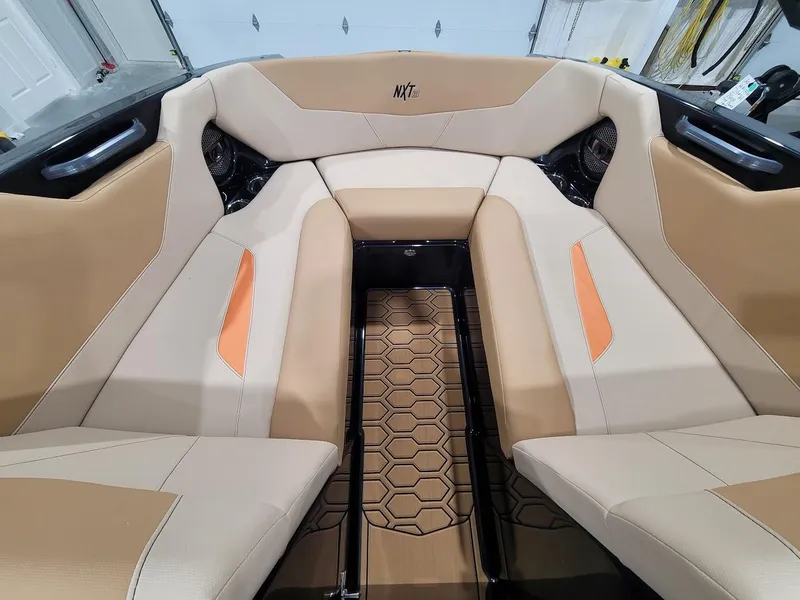 Slide: The Image of 2024 MasterCraft NXT22 boat interior with beige and orange seating. - 15