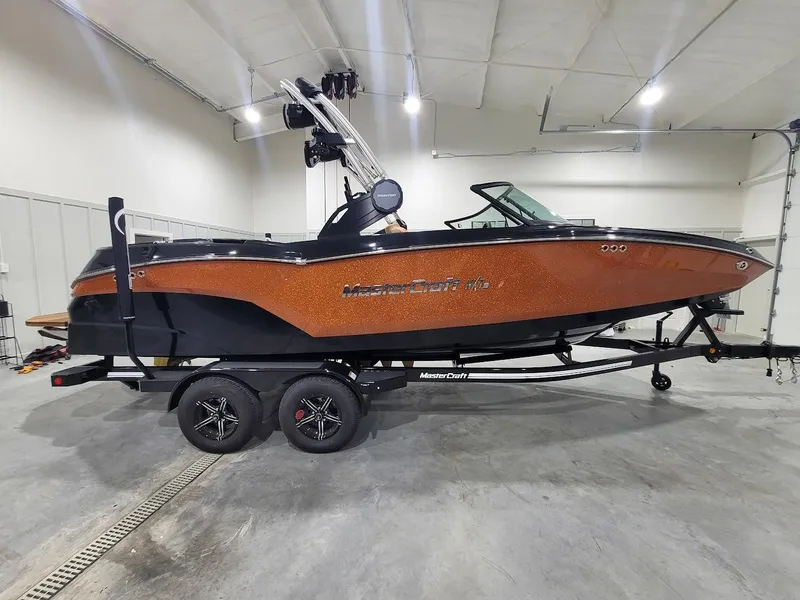 Slide: The Image of 2024 MasterCraft NXT22 boat in showroom, side view. - 9
