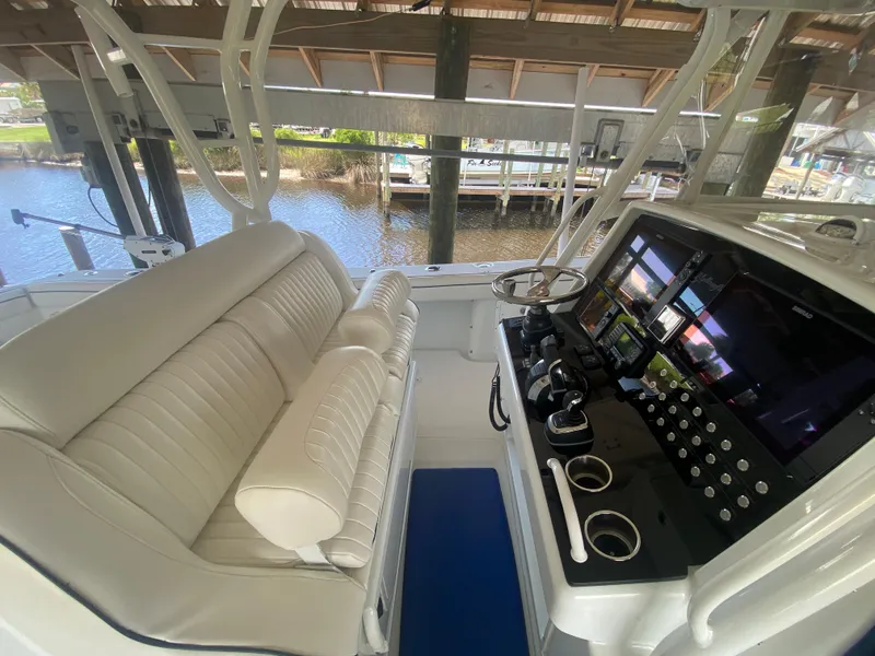 Slide: The Image of 2013 Yellowfin 39 boat cockpit with white seating and advanced control panel. - 13