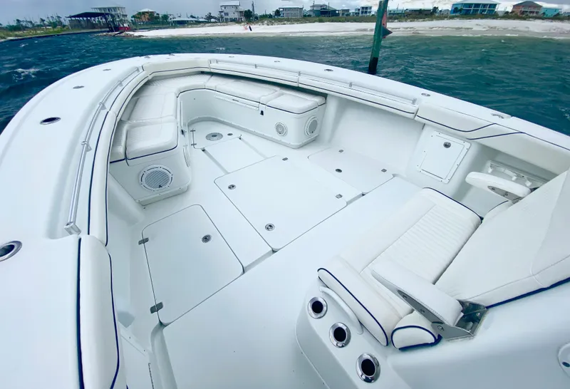 Slide: The Image of 2013 Yellowfin 39 boat with spacious deck and seating, docked near the shore. - 18