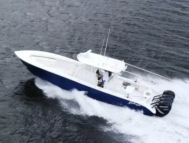 Slide: The Image of 2013 Yellowfin 39 boat cruising on water with triple outboard engines. - 2