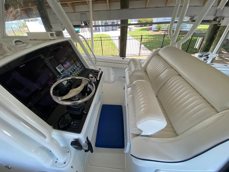 Slide: The Image of 2013 Yellowfin 39 boat cockpit with steering wheel and cushioned seating. - 27