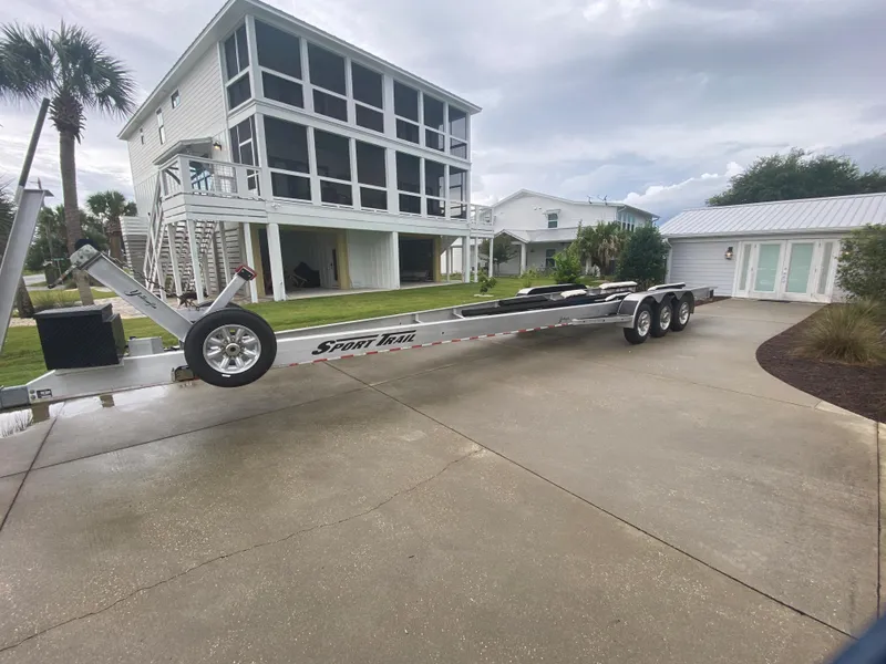 Slide: The Image of 2013 Yellowfin 39 boat trailer parked in driveway near coastal home. - 34