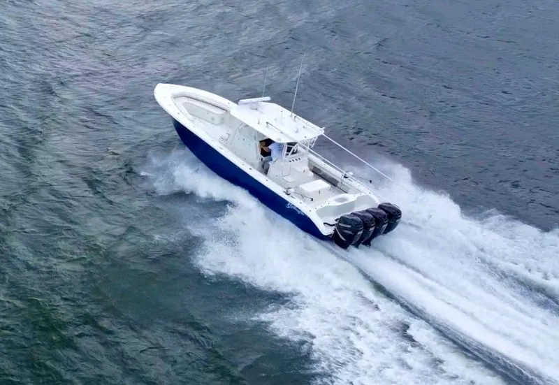 Slide: The Image of 2013 Yellowfin 39 boat cruising on water with triple outboard engines. - 35
