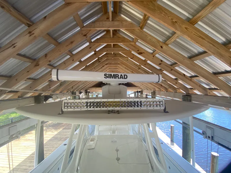 Slide: The Image of 2013 Yellowfin 39 boat under a wooden dock shelter with Simrad radar. - 42