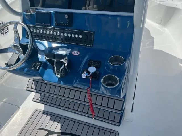 Slide: The Image of 2024 Tidewater 292 CC Adventure boat console with steering wheel and controls. - 10