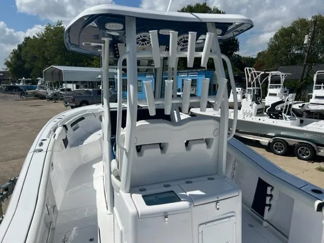 Slide: The Image of 2024 Tidewater 292 CC Adventure boat with T-top and rod holders in a marina. - 5