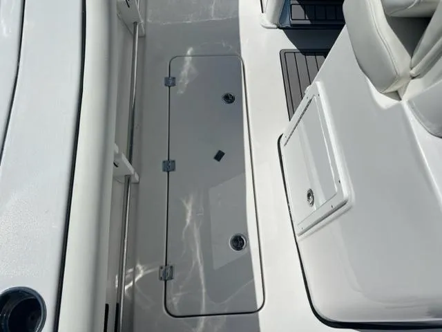 Slide: The Image of 2024 Tidewater 292 CC Adventure boat deck with storage compartment and seating. - 8