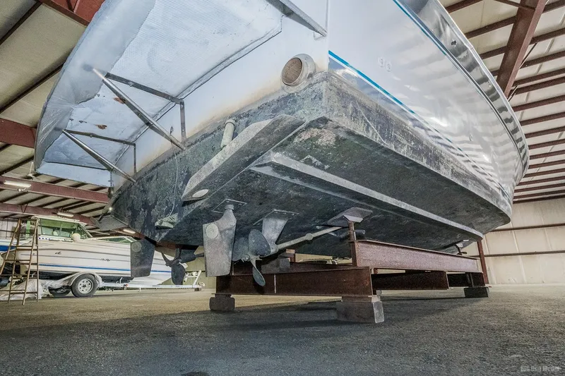 Slide: The Image of 1987 Chris-Craft 320 Amerosport Express boat in storage, showing the underside and propellers. - 13