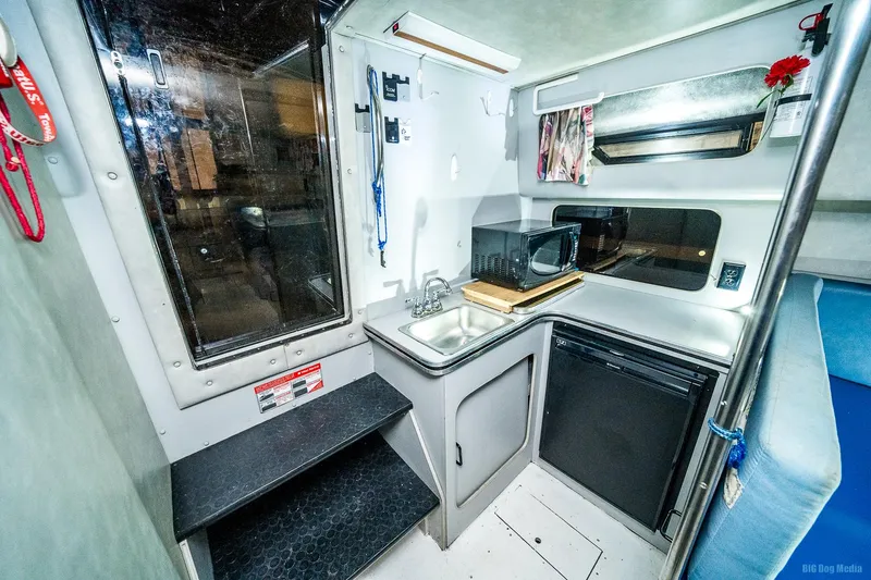 Slide: The Image of 1987 Chris-Craft 320 Amerosport Express galley with sink, microwave, and mini-fridge. - 17