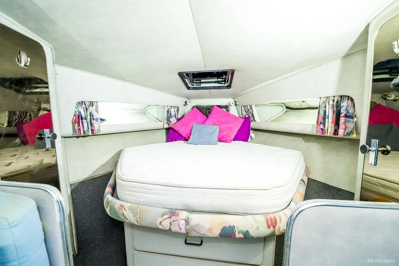 Slide: The Image of 1987 Chris-Craft 320 Amerosport Express cabin with bed and colorful pillows. - 19