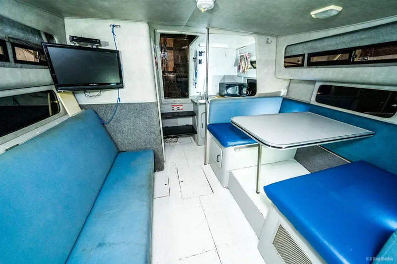 Slide: The Image of 1987 Chris-Craft 320 Amerosport Express cabin interior with blue seating and dining area. - 2