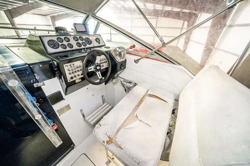 Slide: The Image of 1987 Chris-Craft 320 Amerosport Express cockpit with worn white seating and control panel. - 23