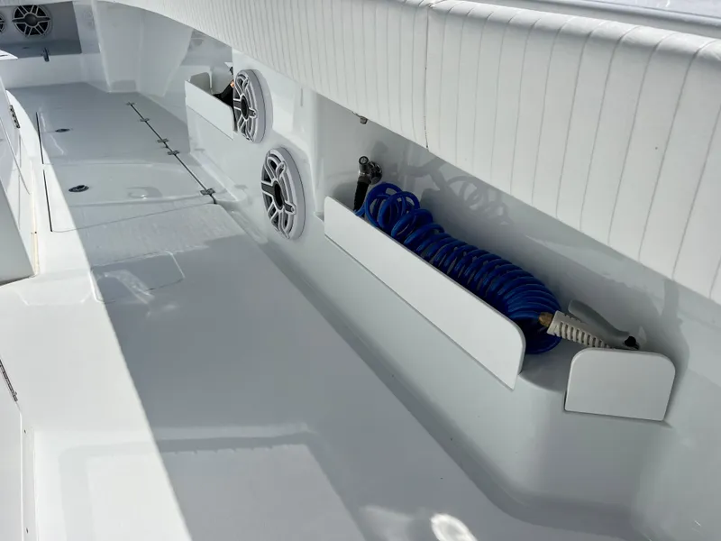 Slide: The Image of 2021 Freeman 37VH boat interior with speakers and coiled blue hose. - 13