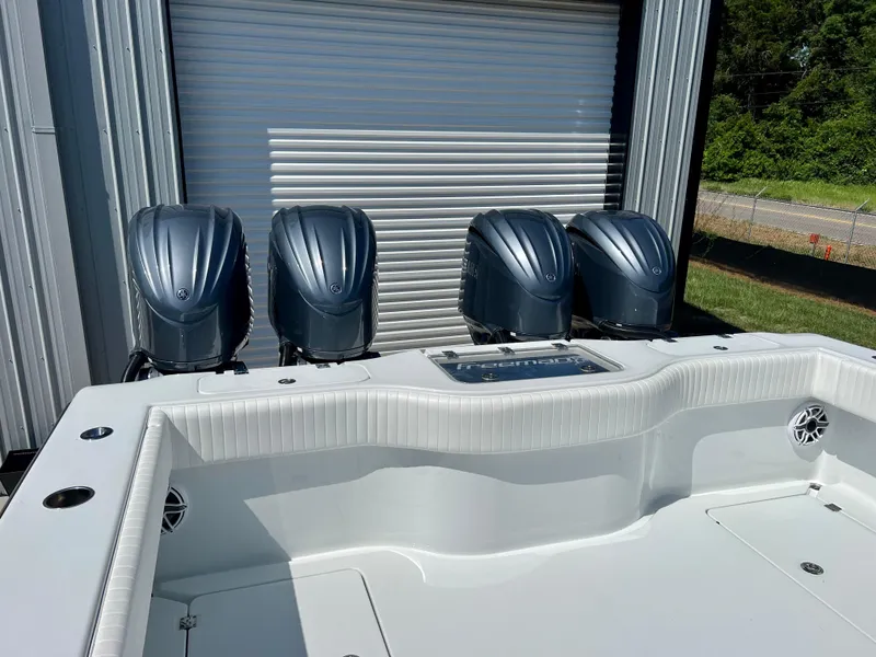 Slide: The Image of 2021 Freeman 37VH boat with four powerful outboard motors, docked near a metal building. - 27