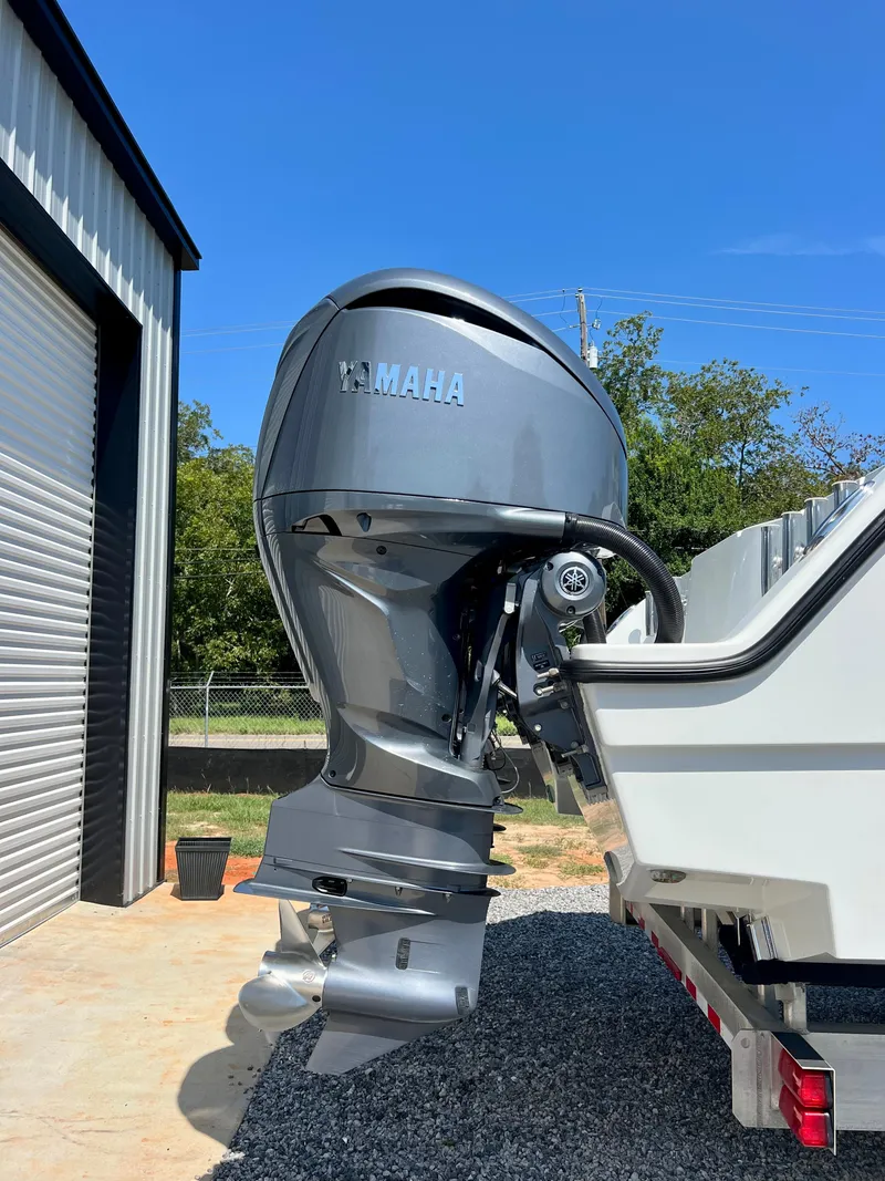 Slide: The Image of Freeman 37VH 2021 boat with Yamaha outboard motor, parked near a garage. - 4