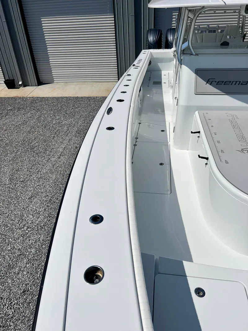 Slide: The Image of 2021 Freeman 37VH boat, sleek white design, docked near a garage. - 9
