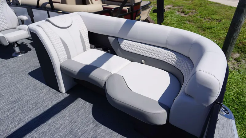 Slide: The Image of Luxurious seating on the 2024 MONACO 235 DFL pontoon boat, featuring plush white and gray upholstery. - 17