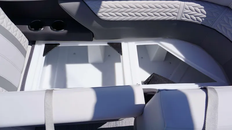 Slide: The Image of 2024 MONACO 235 DFL boat interior storage compartment with cup holders and cushioned seating. - 8