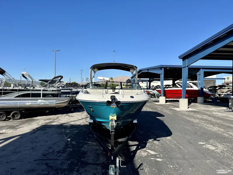 Slide: The Image of 2024 Sea Ray SDX 290 OB boat on trailer in marina under clear blue sky. - 1