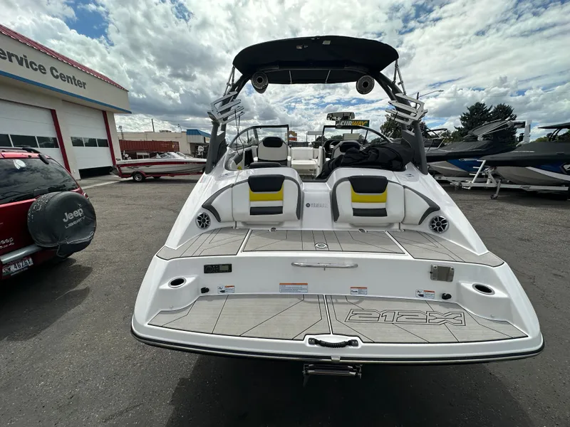 Slide: The Image of 2020 Yamaha 212X jet boat at service center, rear view with seating and deck. - 11