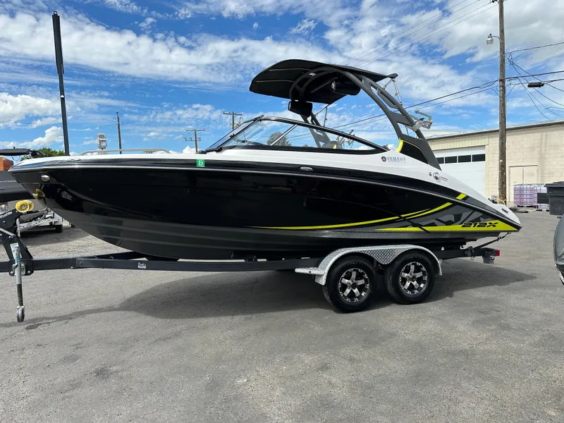 Slide: The Image of 2020 Yamaha 212X jet boat on trailer, black with yellow accents, parked outdoors. - 5