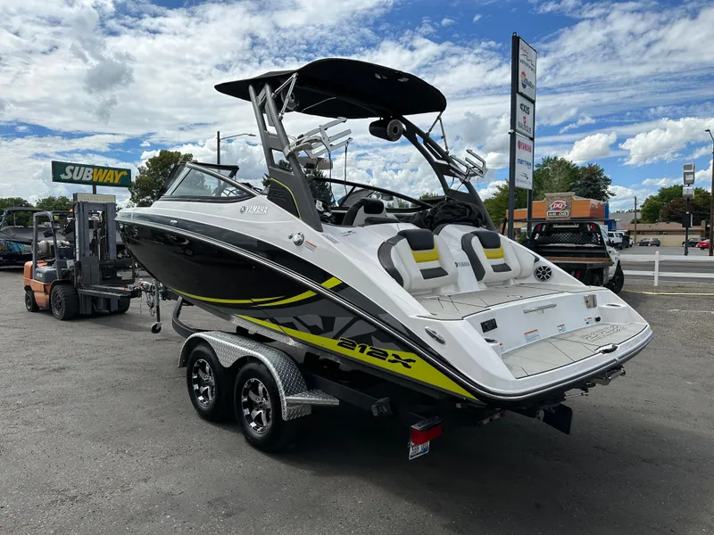 Slide: The Image of 2020 Yamaha 212X jet boat on trailer, parked outdoors near a Subway restaurant. - 6