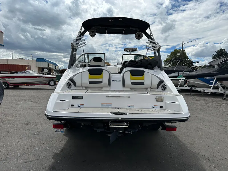 Slide: The Image of 2020 Yamaha 212X jet boat, rear view, in a marina with cloudy sky. - 7