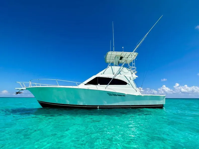 Slide: The Image of 2000 Luhrs 400 Convertible yacht on clear turquoise water under a bright blue sky. - 0