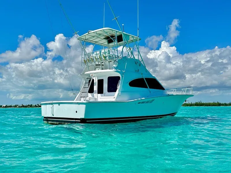 Slide: The Image of 2000 Luhrs 400 Convertible yacht on clear turquoise water under a blue sky. - 1
